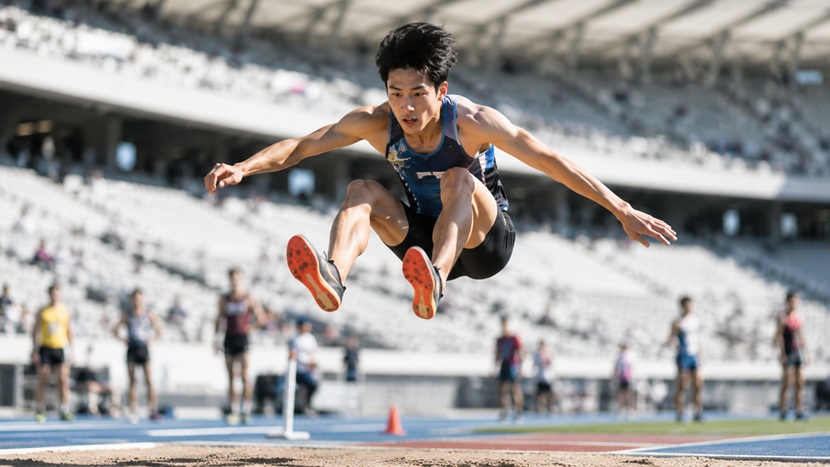 大きく跳躍して飛躍の意味を表現するスポーツ選手