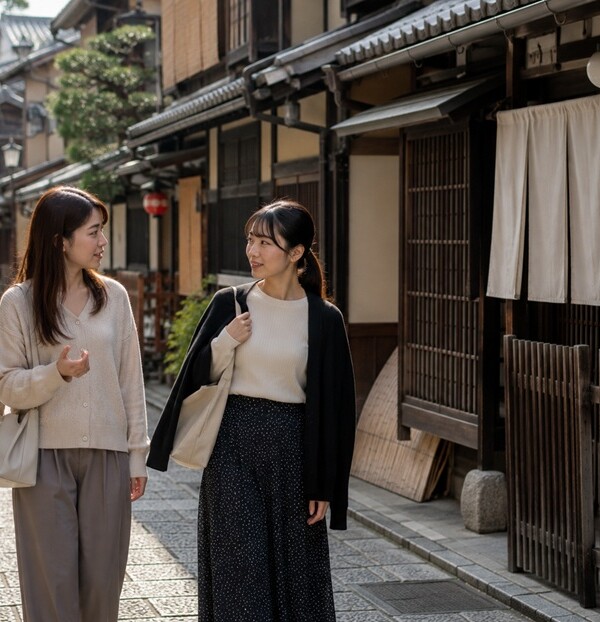 京都の町家が並ぶ通りで京都弁を話す女性二人