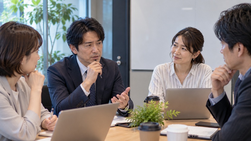 職場の打ち合わせで相手に配慮しながら発言する会社員