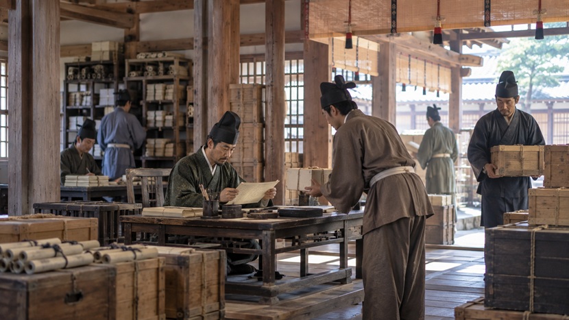 古い時代の役所で文書や物品を扱う役人たち