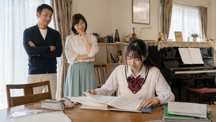 音楽が好きな親に見守られながらピアノに取り組む娘